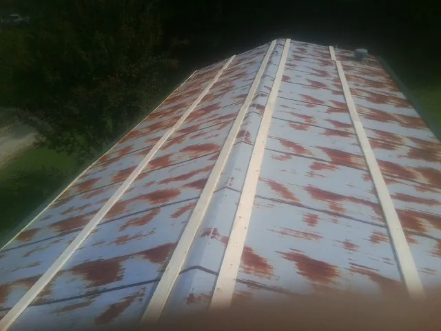 Rusted metal roof panels with new wood purlins before replacement — Storm Damage Roof Repair in Saint Marys City by Roofing Brothers