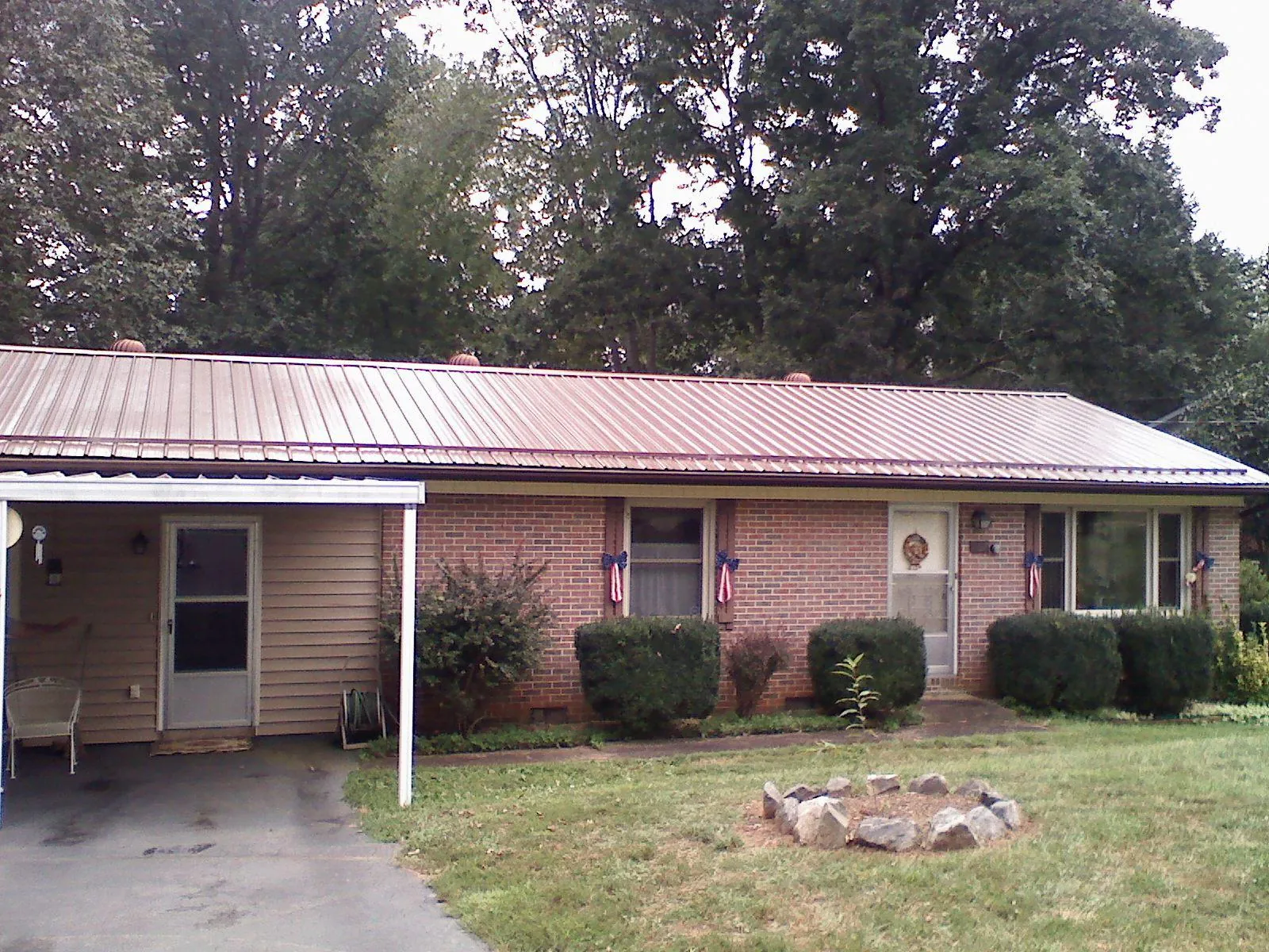 Bronze metal roof and carport on a brick ranch home — Roof Repair work by our crew in Saint Marys City